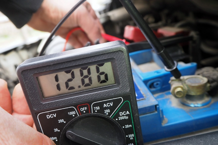 Battery tester connected to a vehicle battery.