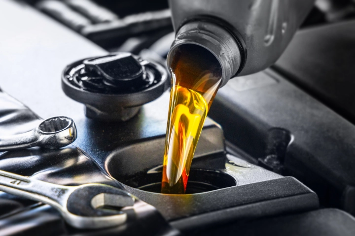Oil being poured into an engine fill port.